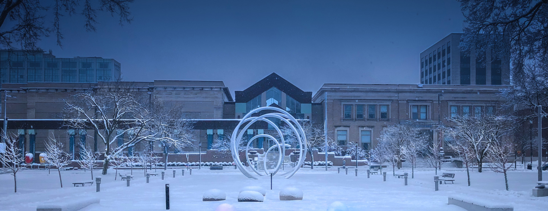 A sculpture in Greene Square is surrounded by winter snow.