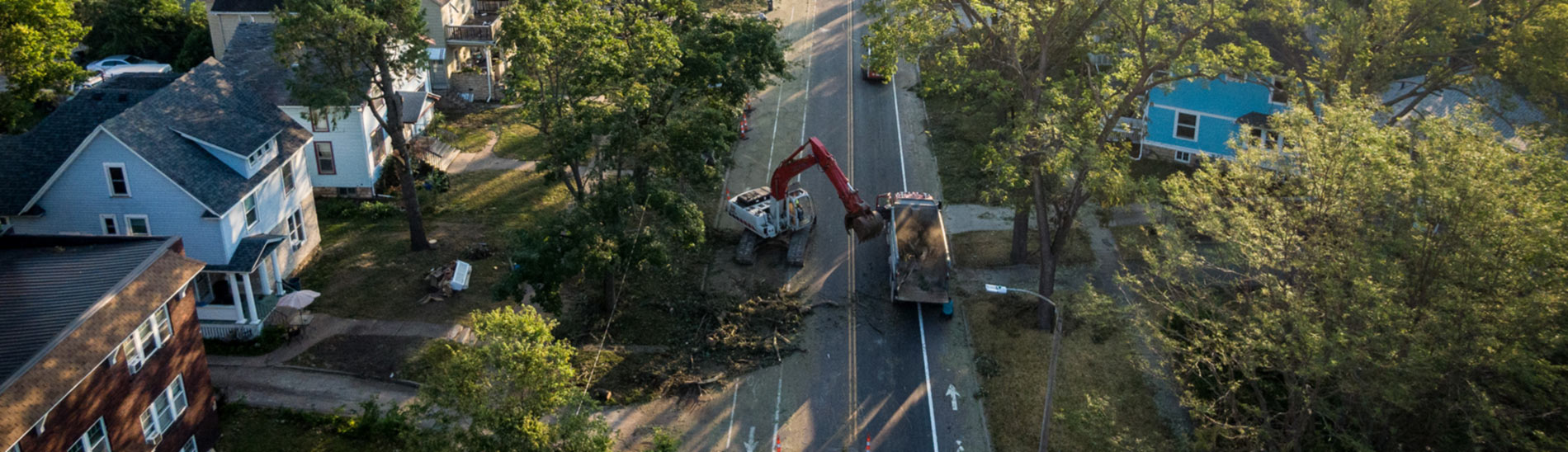 Aerial photo of heavy machinery cleaning up tree debris after a storm.